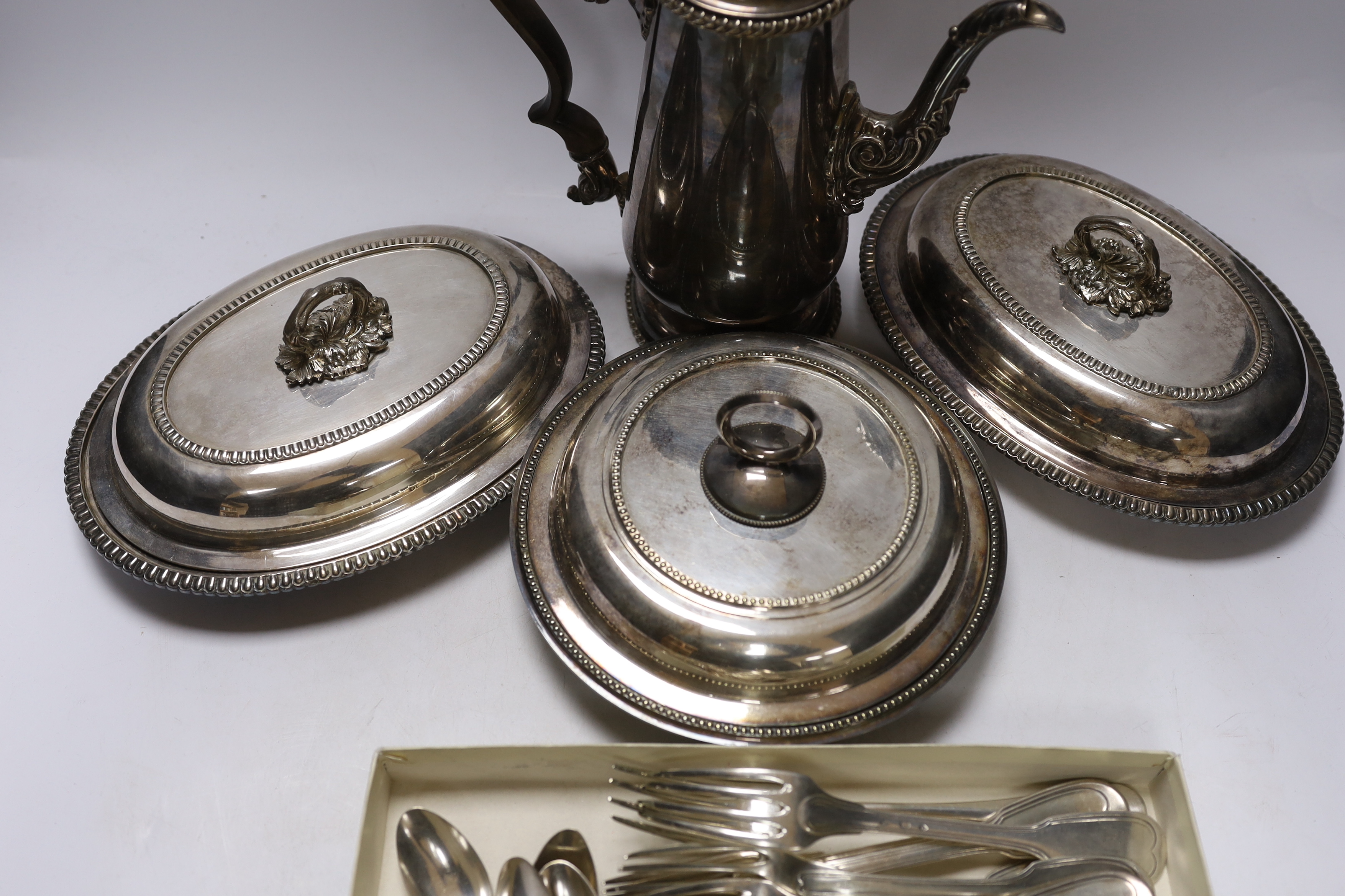 Assorted plated wares including Christofle flatware, coffee pot and three serving dishes.